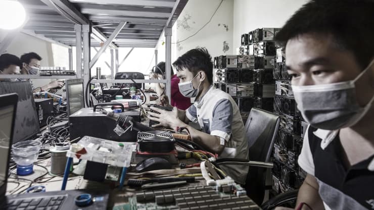 Các kỹ thuật viên tiến hành sửa chữa máy khai thác bitcoin tại một cơ sở khai thác do Bitmain điều hành ở Ordos